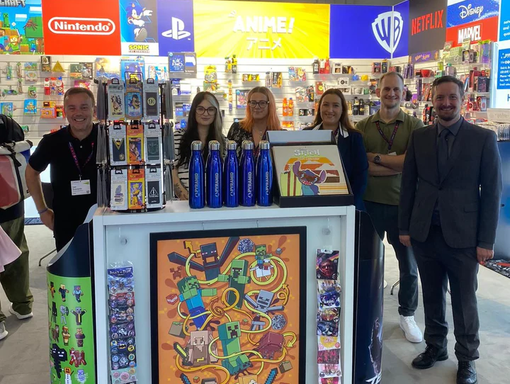 International Sales Team at Gamescom 2024 booth, displaying a range of merchandise and engaging with attendees.